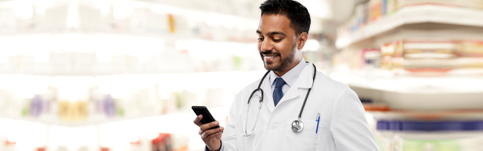 pharmacist in white coat with smartphone