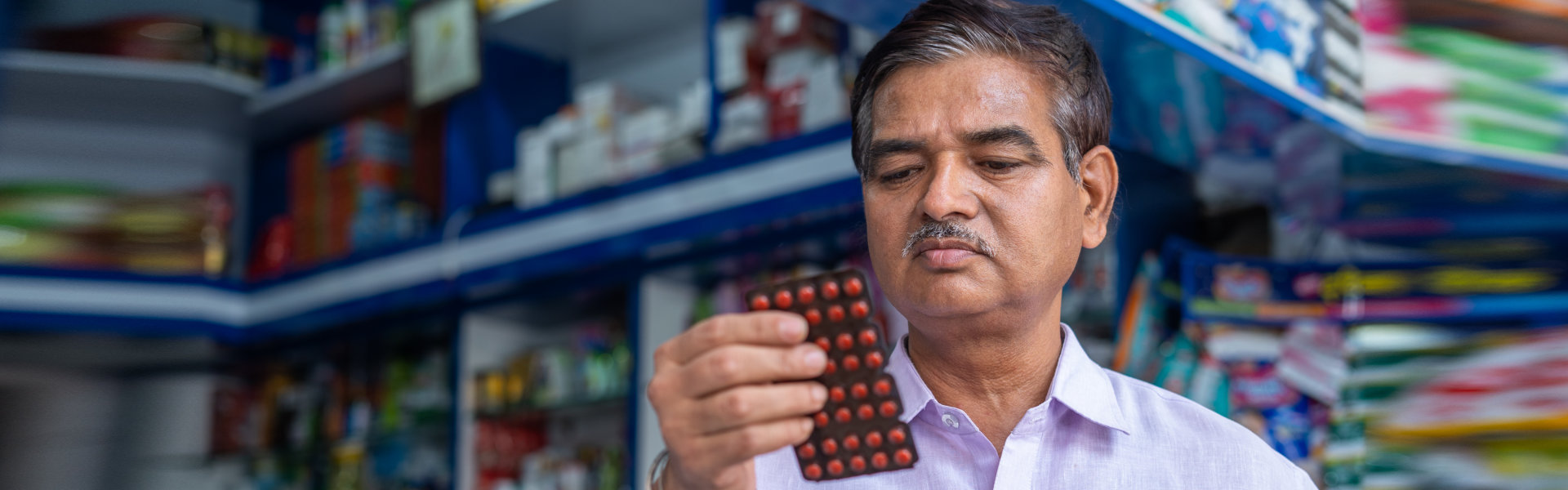 customer checking medicine price and expiry date at retail medical shop after purchasing