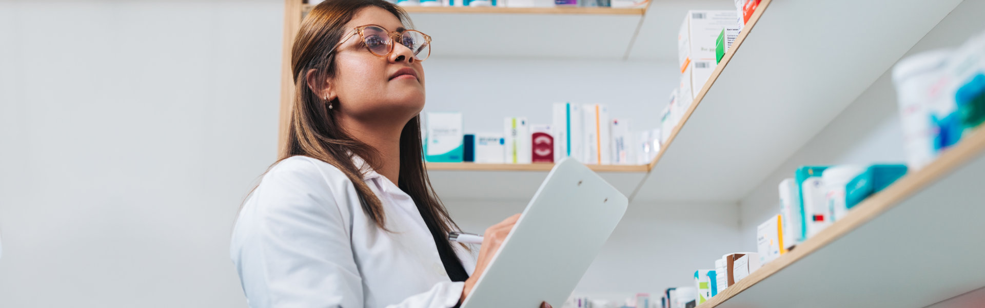 Female pharmacist writing on a clipboard