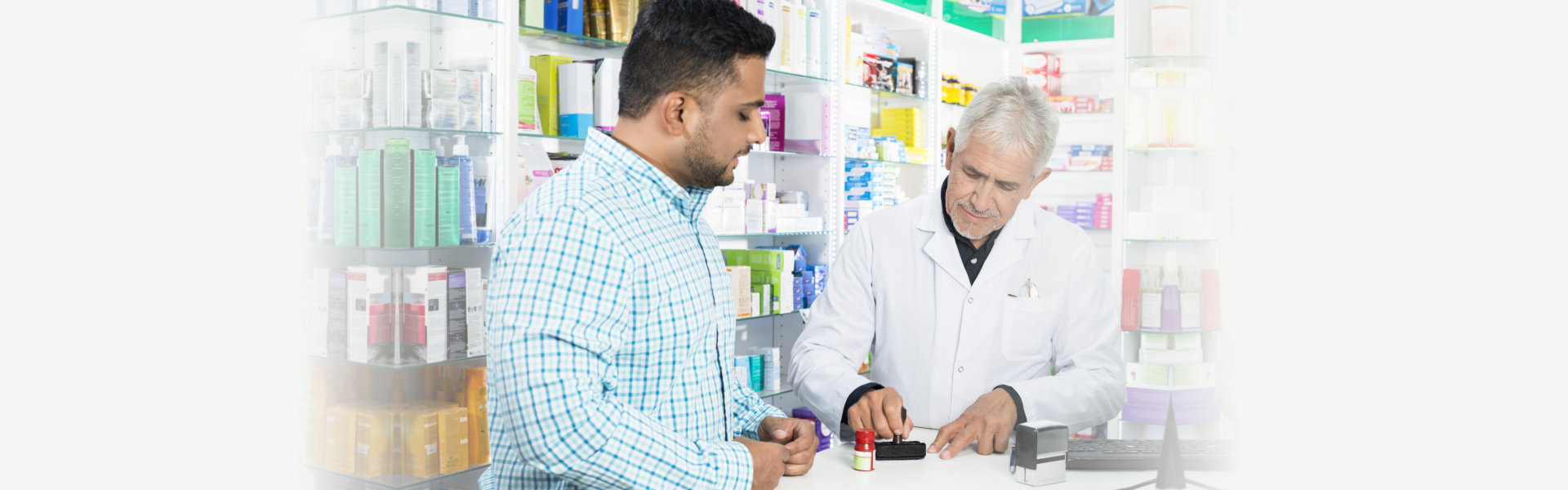 Pharmacist Stamping Paper While Customer Standing At Counter