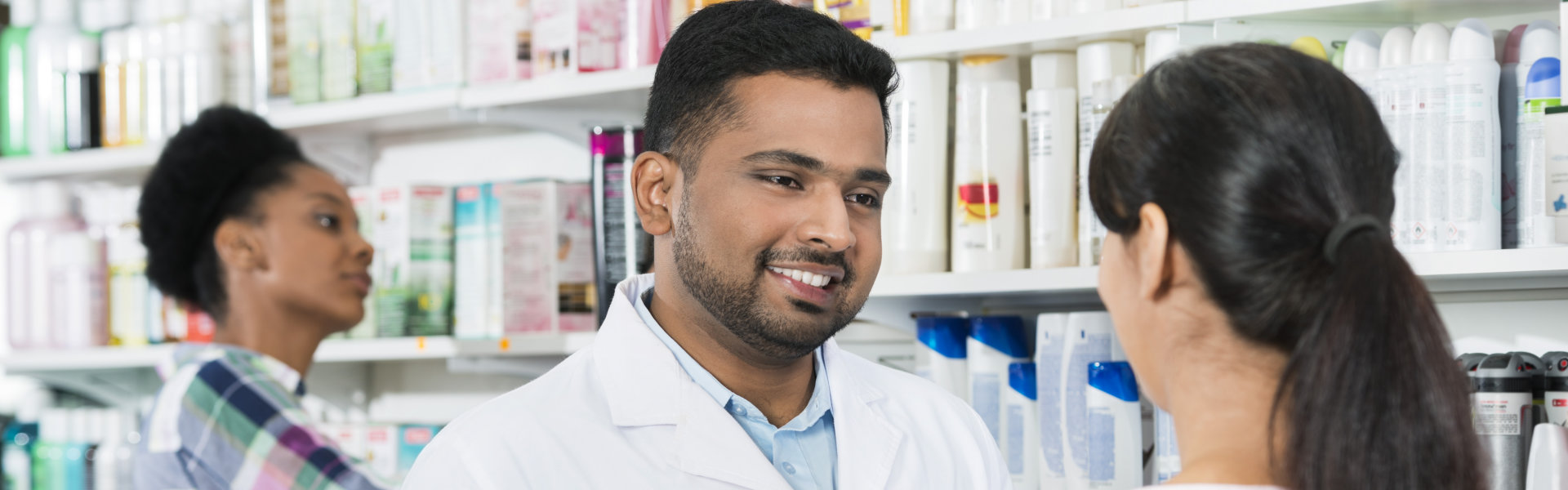 Young Pharmacist Assisting Female Customer