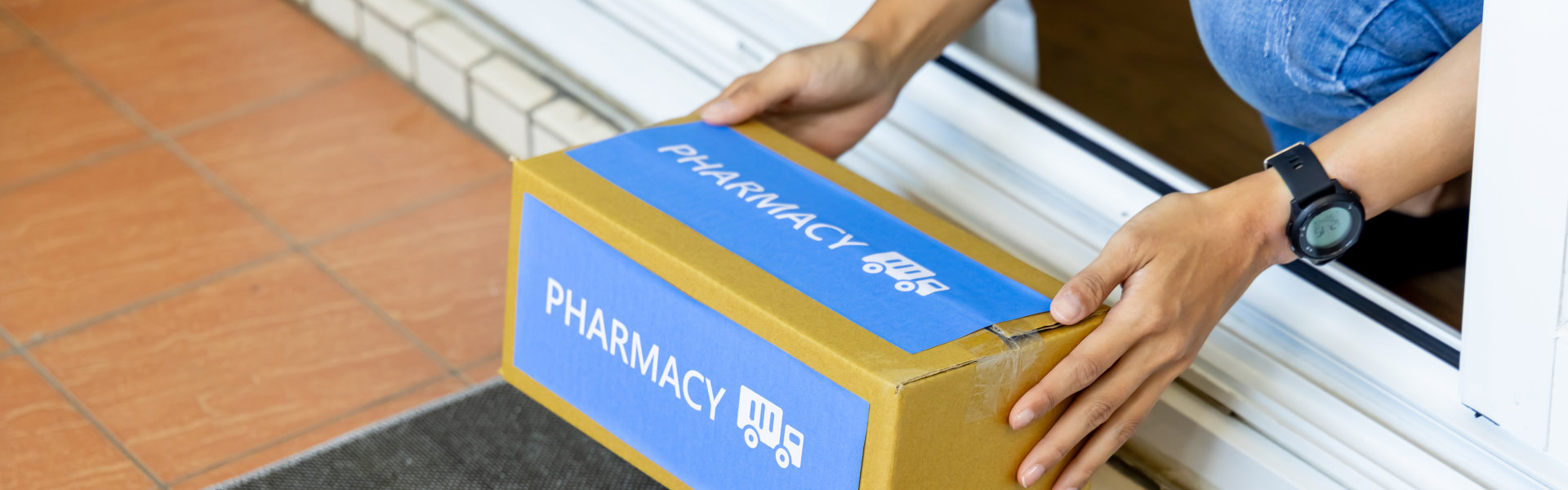 person picking up a box from pharmacy